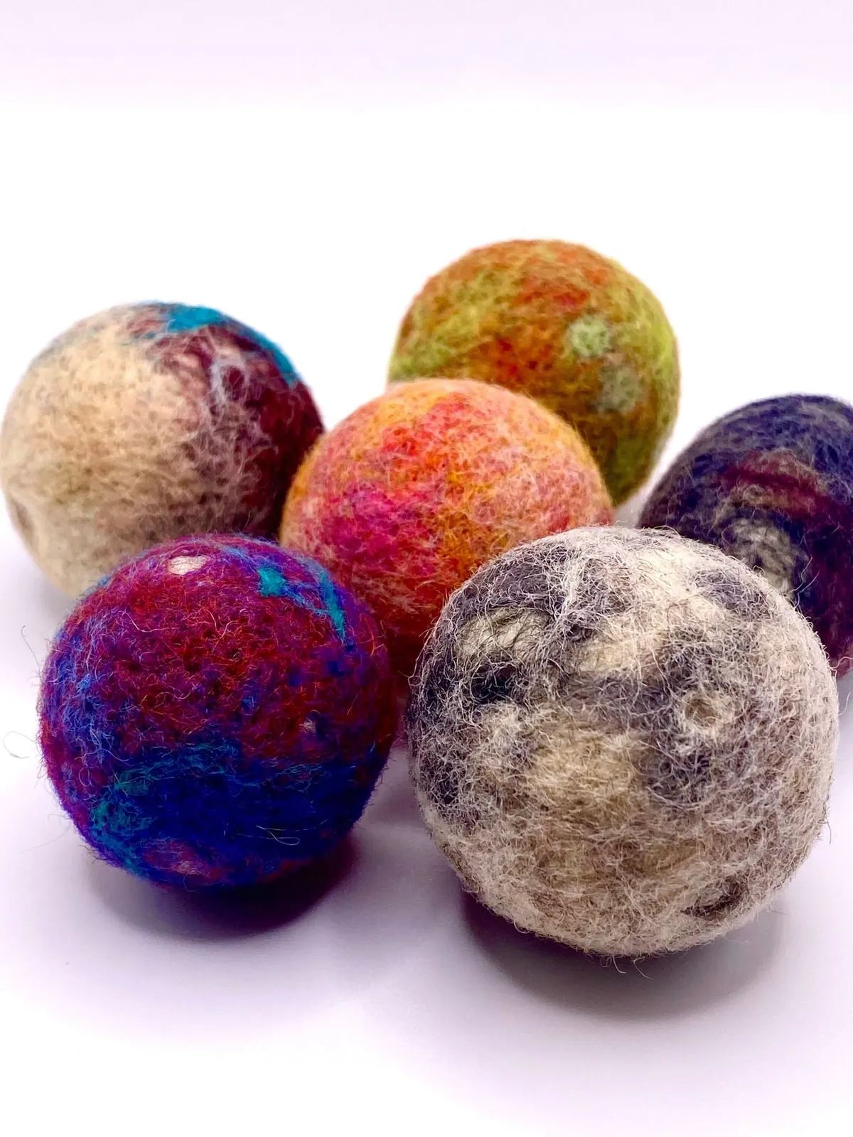 The five dwarf planets grouped together, mottled in cream, red and deep blue.